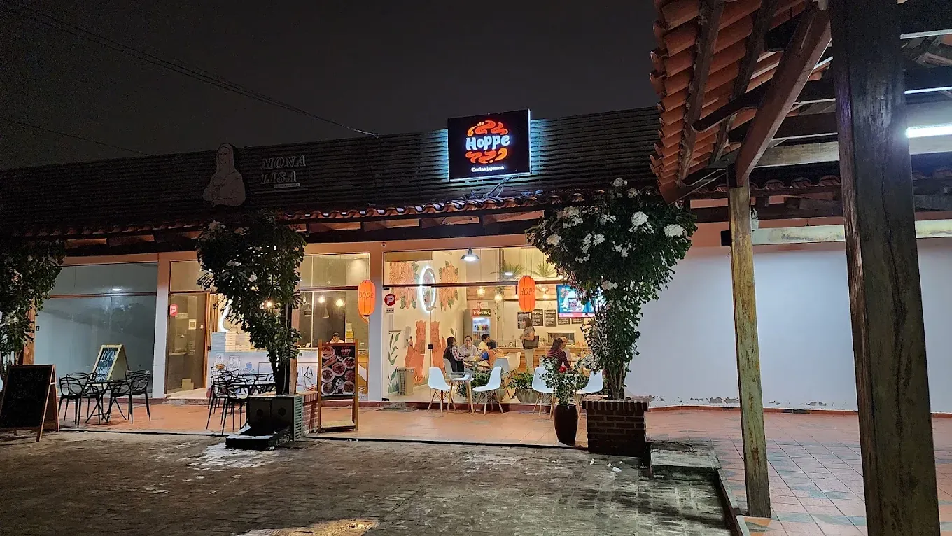 Fachada de Hoppe de noche, con su letrero iluminado y faroles