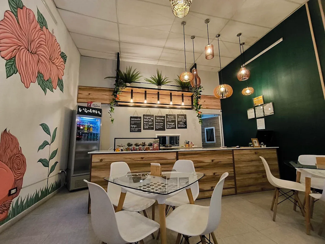 Salón de Hoppe con el mural de hibiscos, lámparas de madera y la pared verde